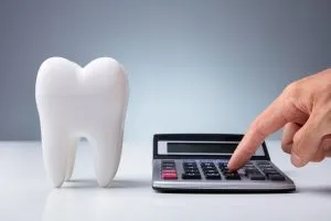 A calculator next to a large fake tooth