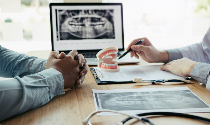 Patient speaking with doctor before oral surgery